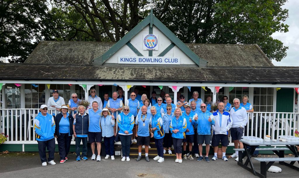 Image showing Kings bowling club members in club colours. They are stood in front of their clubhouse